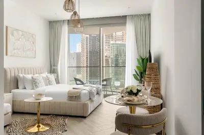 a living room with a bed and a table with chairs at Chic Studio in Peninsula Three, Business Bay in Dubai