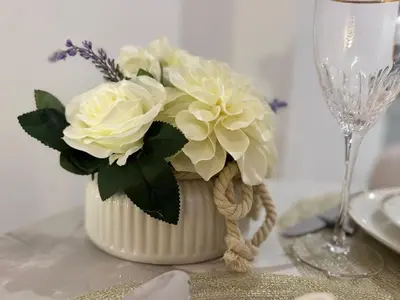 a white vase with white flowers on a table at Chic Studio in Peninsula Three, Business Bay in Dubai