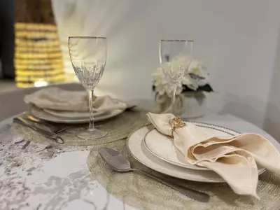 a table with two plates and a wine glass at Chic Studio in Peninsula Three, Business Bay in Dubai
