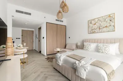 a bedroom with a large bed and a living room at Chic Studio in Peninsula Three, Business Bay in Dubai