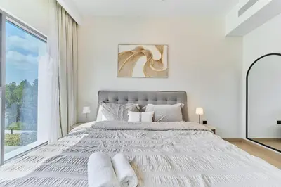a white bedroom with a large bed and a window at Premium 3 Bedroom Townhouse in DAMAC Lagoons in Dubai