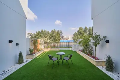 a patio with a table and chairs on the grass at Premium 3 Bedroom Townhouse in DAMAC Lagoons in Dubai