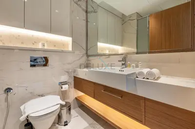a bathroom with a sink and a toilet and a mirror at Open layout Studio with Balcony - Azizi Riviera 67, Al Merkadh by Deluxe Holiday Homes in Dubai