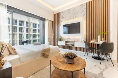 a hotel room with a king sized bed and a desk at Open layout Studio with Balcony - Azizi Riviera 67, Al Merkadh by Deluxe Holiday Homes in Dubai