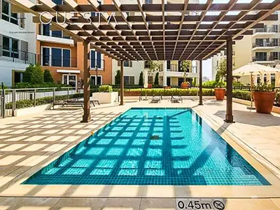 a swimming pool under a pergola in a courtyard at Luxury Loft 1 Bedroom La Voile - Building 1 Jumeirah 1 in Dubai