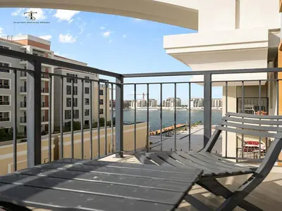 a bench on a balcony with a view of the water at Luxury Loft 1 Bedroom La Voile - Building 1 Jumeirah 1 in Dubai