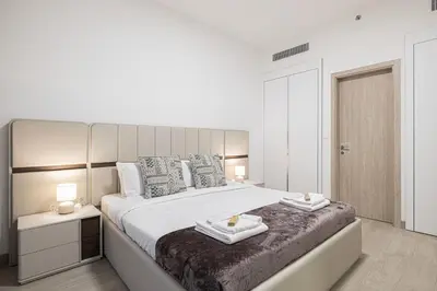 a bedroom with a large bed with two candles on it at Restay Homes at Luma22 West Tower in Dubai