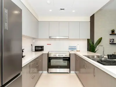 a kitchen with white cabinets and a stainless steel oven at Royal Vista25 - 4BR with Billiard Table at Forte Tower Downtown Dubai in Dubai