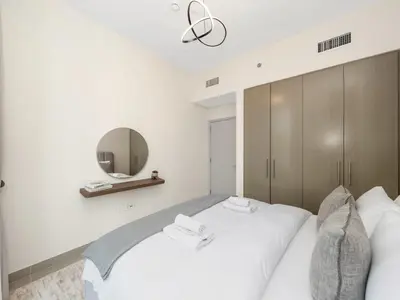 a bedroom with a white bed and a mirror at Royal Vista25 - 4BR with Billiard Table at Forte Tower Downtown Dubai in Dubai