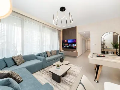 a living room with a blue couch and a tv at Royal Vista25 - 4BR with Billiard Table at Forte Tower Downtown Dubai in Dubai