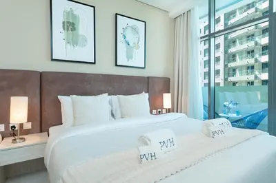 a bedroom with a large bed with two pillows on it at PVH - Seven Palm - Modern Studio with Beach Access near Palm Jumeirah Mall in Dubai