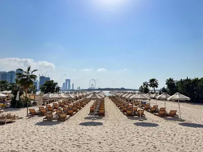 a row of chairs and umbrellas on a beach at PVH - Seven Palm - Modern Studio with Beach Access near Palm Jumeirah Mall in Dubai