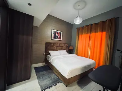 a bedroom with a bed and a chair in it at Remraam Holiday Home Dubai in Dubai