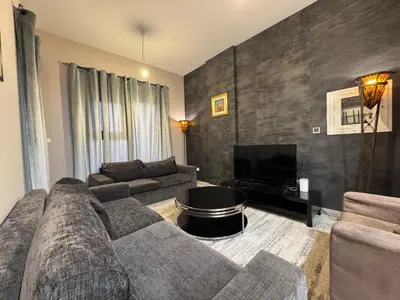 a living room with a couch and a tv at Remraam Holiday Home Dubai in Dubai