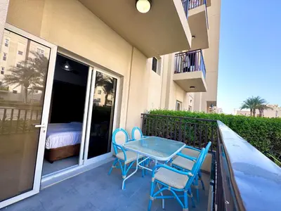 a patio with a table and chairs on a balcony at Remraam Holiday Home Dubai in Dubai