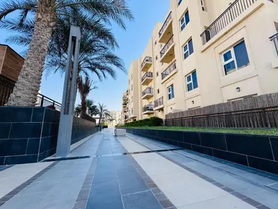 a sidewalk in front of a building with a palm tree at Remraam Holiday Home Dubai in Dubai