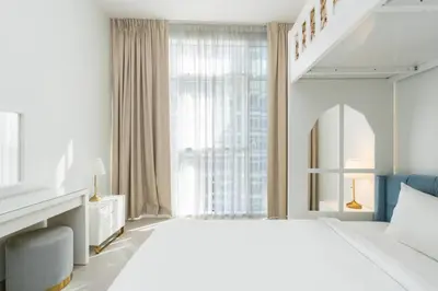 a white bedroom with a large bed and a window at CitiHome - Spacious 2BR - Park Gate Residences in Dubai