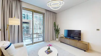 a living room with a couch and a tv at Vacationer l Vida T2 1 Bedroom l Direct Access to Dubai Mall in Dubai