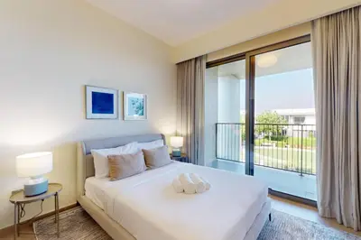 a bedroom with a large white bed and a balcony at Vacationer l Incredible 5 Bed l Private Garden l near Mall in Dubai