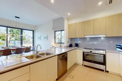 a kitchen with a sink and a stove top oven at Vacationer l Incredible 5 Bed l Private Garden l near Mall in Dubai