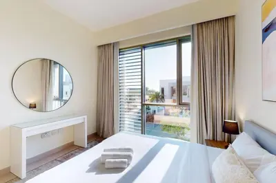 a bedroom with a large white bed and a mirror at Vacationer l Incredible 5 Bed l Private Garden l near Mall in Dubai