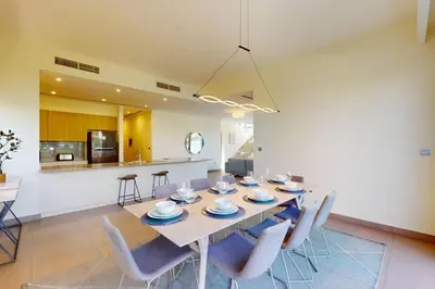 a dining room and kitchen with a table and chairs at Vacationer l Incredible 5 Bed l Private Garden l near Mall in Dubai