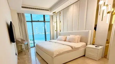 a bedroom with a bed and a large window at Beachfront comfort your private escape at Palm jumeriah th8 residences in Dubai