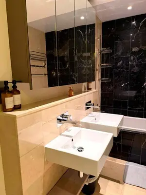 a bathroom with two sinks and a mirror at Beachfront comfort your private escape at Palm jumeriah th8 residences in Dubai