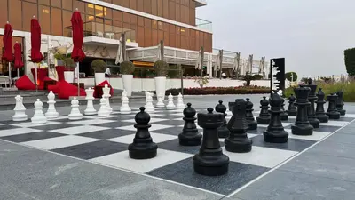 a chess board with chess pieces on a sidewalk at Beachfront comfort your private escape at Palm jumeriah th8 residences in Dubai