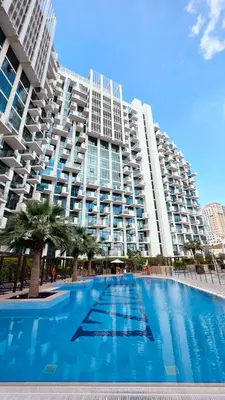 a large apartment building with a large swimming pool at Modern Deluxe Studio in Dubai in Dubai