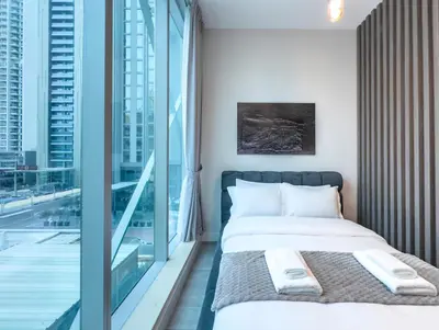 a bedroom with a bed and a large window at Marina Elegance, Walk to JBR Beach and Ain Dubai w Stunning Canal View in Dubai