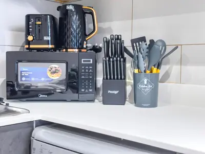 a kitchen counter with a microwave and utensils at Marina Elegance, Walk to JBR Beach and Ain Dubai w Stunning Canal View in Dubai