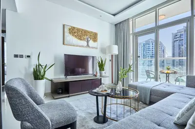 a living room with a couch and a tv at Frank Porter - Damac Maison Prive in Dubai