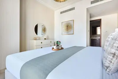a bedroom with a white bed and a mirror at Frank Porter - Boulevard Point in Dubai