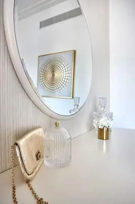 a white bathroom with a mirror and a purse at Frank Porter - Boulevard Point in Dubai