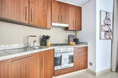a kitchen with wooden cabinets and a stove top oven at Frank Porter - Boulevard Point in Dubai