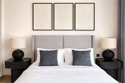 a bedroom with a large white bed with two lamps at Binghatti Phoenix Luxe 1BR with Tranquil Pool View in Dubai