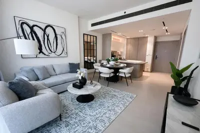 a living room with a couch and a table at Binghatti Phoenix Luxe 1BR with Tranquil Pool View in Dubai