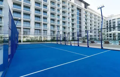 a tennis court in front of a building at Binghatti Phoenix Luxe 1BR with Tranquil Pool View in Dubai