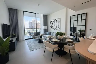 a living room with a table and a couch at Binghatti Phoenix Luxe 1BR with Tranquil Pool View in Dubai