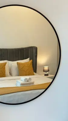 a mirror reflecting a bed in a bedroom at 1BDR Large Living Room Nearby Metro in Dubai