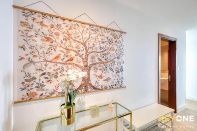 a painting of a tree on a wall in a hallway at Spectacular Marina Views Luxurious Two Bedroom in Dubai