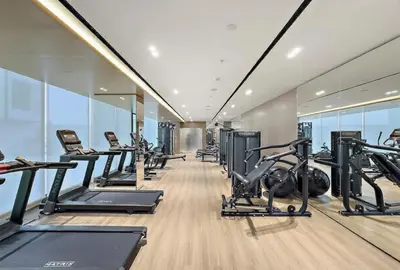 a gym with treadmills and elliptical machines at HAVN - Studio in Binghatti Dawn, JVC in Dubai