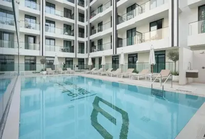 a swimming pool in front of a building at HAVN - Studio in Binghatti Dawn, JVC in Dubai