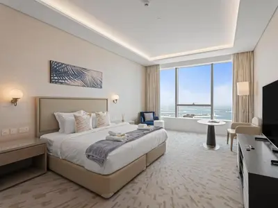a hotel room with a bed and a television at Sunset Bliss Elegant Palm Island Studio in Dubai