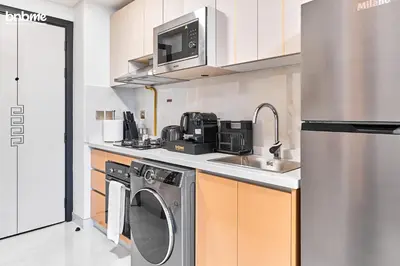 a kitchen with a sink and a washing machine at bnbmehomes - Skyz by Danube in Dubai
