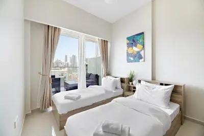 a hotel room with two beds and a window at Modern 2BR I DAMAC Reva Residences I Canal Views in Dubai