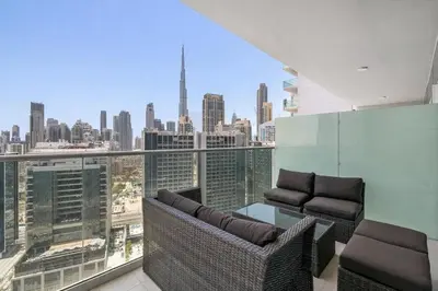 a balcony with two chairs and a view of the city at Modern 2BR I DAMAC Reva Residences I Canal Views in Dubai