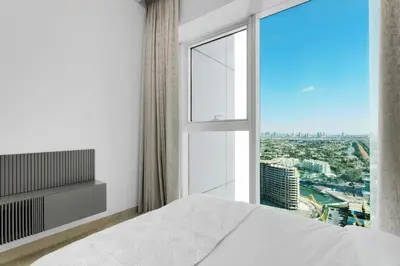 a bedroom with a white bed and a large window at Spacious 3BR and Study with Multiple Ensuites Medore Residence in Dubai