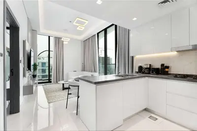 a kitchen with white cabinets and a counter top at Luxury 1BR with Private Pool & Balcony in Dubai